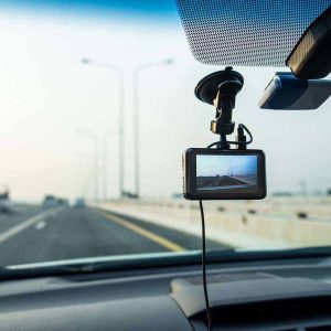 Car video camera (dash cam) installed inside of car running on highway with blurred background of highway road, looking from perspective of the driver. Concept of safety camera for car protection, technology for safety